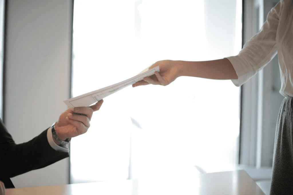 One hand passing a document to another