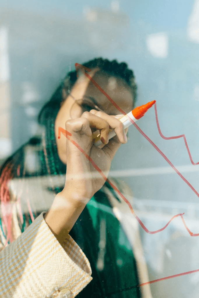 Woman drawing a rising chart on a glass board